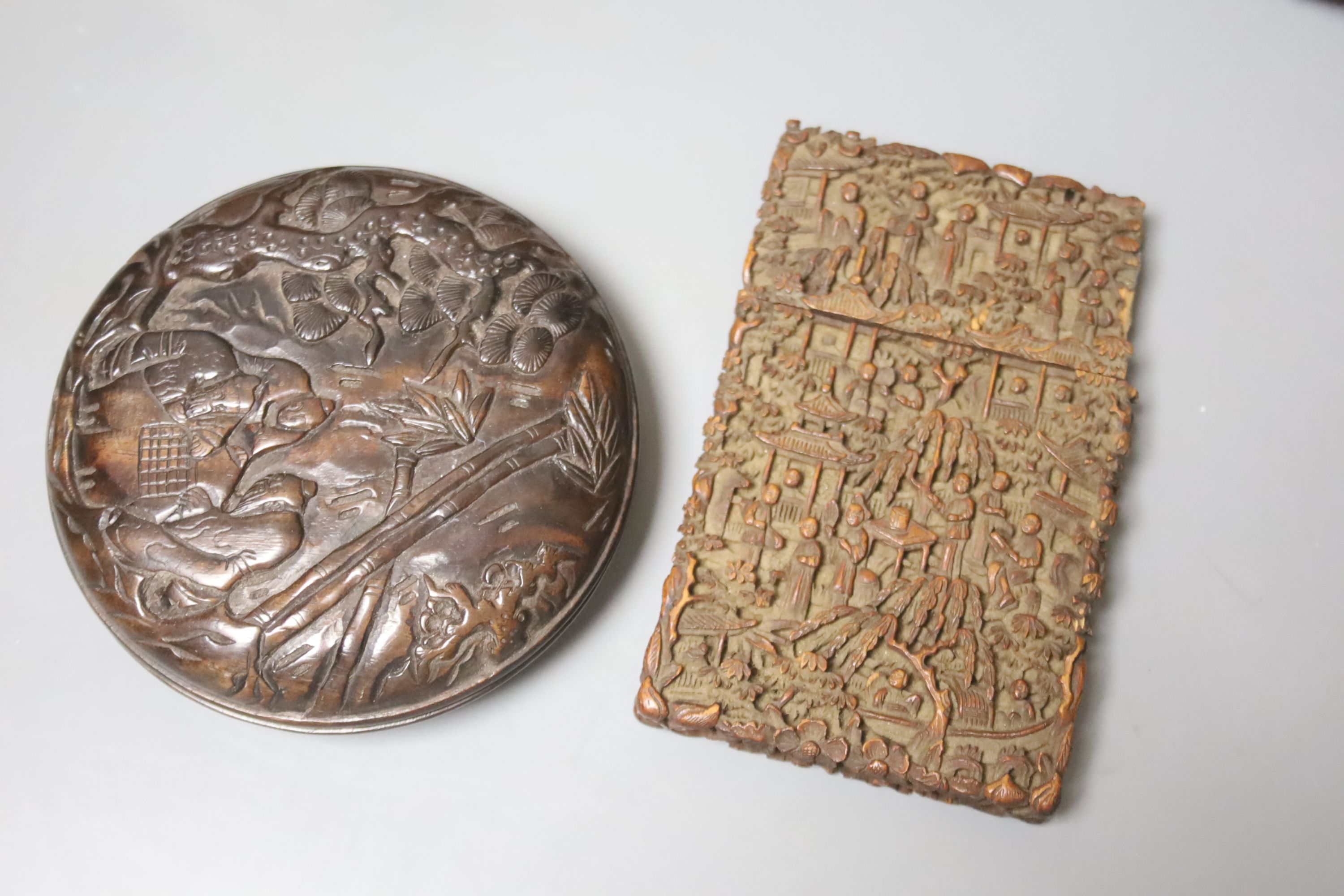 Five Chinese wood carvings including a circular box and a card case, largest 23cm wide